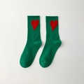Green mid-calf cotton socks featuring a large red heart pattern in a minimalist flat lay - Green