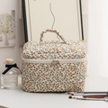 Detailed close-up of quilted floral makeup bag with dual zippers and cream cotton texture - Large Yellow Floral