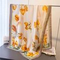 Detalle de bufanda de seda con flores naranja y marfil colgada en un soporte de metal fino - Café (Estampado Floral Vintage)