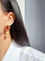 Close-up of a vintage gold earring with a red faceted gemstone and a champagne pearl - Style 2