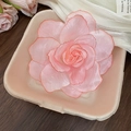 Détail d'une pince à cheveux fleurie en tissu avec pétales roses et liseré rouge - Rose