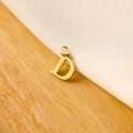 Macro shot of a polished gold letter D charm on textured fabric and light wood background - 14k Letter - D (letter Height 1cm)