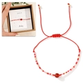 Detail eines roten gewebten Armbands mit Rubinperle und Kraftpapier-Geschenkbox - Januar Geschenkbox Plus/Rot