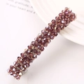 Macro shot of purple faceted crystal beads on a metallic hair clip with elegant styling - Purple