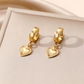 Hip hop style gold heart hoop earrings with intricate beaded edges on a beige display - Heart