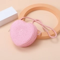 Detailed view of pink heart-shaped straw bag with intricate woven texture on warm background - Water Pink