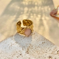 Detail of gold geometric ring featuring a pink opal stone and quilted metal texture - Adjustable Open / Gold/Pink