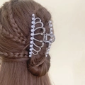 Dettaglio del fermaglio per capelli in metallo argento con perle su un'acconciatura raccolta - Corona / Argento