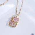 Close-up of gold titanium necklace with pink zircon floral pendant on white fabric - Rectangular Pink Flower