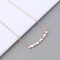 Close-up of rose gold hexagonal pendant set with sparkling zircon on a delicate cross chain - Necklace / Rose Gold