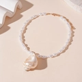 Detalle de collar de perlas blancas con colgante de caracol natural y cierre dorado - Collar de Perla Pequeña de Caracola