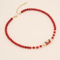 Detail showing red beaded necklace with gold LOVE engraved cylindrical pendant charm - Red Turquoise Style (LOVE/Red Beads)