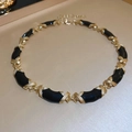 Dettaglio della collana vintage in smalto con maglie strutturate nere e oro - Oro-Nero