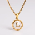 Detailed view of golden necklace with a white shell pendant and a central letter L - Letter L