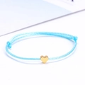 Minimalist blue woven cord lucky bracelet with a small golden heart pendant detail - Sky Blue/Gold