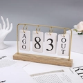 Dettaglio di un calendario a fogli mobili creativo con cornice in metallo dorato e base - Oro