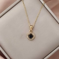 Detail of gold necklace with round blue stone pendant on elegant jewelry display - Gold Royal Blue Zirconia