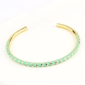Detailopname van de gouden open armband met mintgroene emaille spiraal in boho-stijl - Groen
