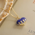 Collana cuore lava con ciondolo a goccia blu e finitura oro su sfondo di libro - Viola