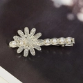 Silver metal daisy hair clip with sparkling rhinestones and elegant pearls on dark background - Pearl Daisy