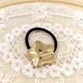 Golden irregular star hair tie with black elastic band on elegant white lace fabric - Gold Star