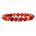 Macro shot of red agate beaded bracelet with polished texture and silver metal spacer bead - Orange Striped Agate