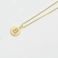 Detail shot of a minimalist gold necklace with a circular pendant featuring letter B - Letter B