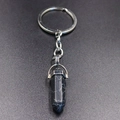 Macro detail of hexagonal natural stone pendant on a silver metal keychain - Black Turquoise