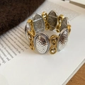 Detailed close-up of retro two-tone textured heart stretch bracelet on a vintage book - 4# Gold-Silver Hammered Infinity Symbol Bracelet
