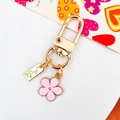 Golden flower keychain with pink enamel petal pendant and handmade engraved metal tag - Pink