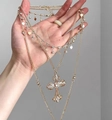 Detail of layered gold necklace featuring crystal cross and heart pendants on a hand - Gold Heart Rhinestone Cross Multilayer Necklace