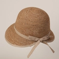 Detailed view of woven raffia sun hat featuring elegant ribbon trim and stylish side bow - M (56-58cm) / Khaki