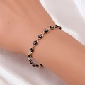 Detail van de gouden Evil Eye armband met zwart-witte kralen op witte zijde - Gouden Zwarte Armband