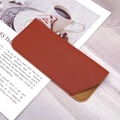 Detailed view of monogram PU leather sunglasses pouch with fine stitching on a magazine - Brown Plain