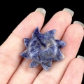 Carved sun shape blue sodalite natural stone showing unique white and gray patterns - Blue Sodalite