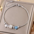 Detail of gold star and evil eye charms on a stainless steel snake chain bracelet - Silver B-250S (Evil Eye/Star)