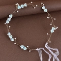Dettaglio fascia per capelli da sposa con fiori azzurri e perle su sfondo in pelle - Blu