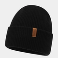 Gros plan du bonnet en maille côtelée noire avec écusson logo en cuir marron premium - Taille unique / Noir