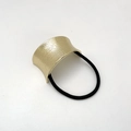 Detail of gold metal U-shaped hair tie with brushed texture and black elastic cord - Sand Gold