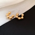 Macro detail of gold beaded C-shape stud earrings on textured black and white fabric - Gold Beaded C-Shape