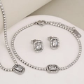 Silver jewelry set featuring rectangular clear stones on a white round display stand - Silver Square