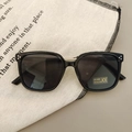 Close-up of UV400 kids square sunglasses on canvas bag in a soft lifestyle setting - Black