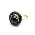Detailed view of adjustable gold ring with faceted black gemstone in a bold circular frame - Obsidian