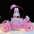 Pink carriage musical snow globe with doll and cat on a soft white plush background - MK Medium 80 Snowfall + Color Light / 2055 Pink