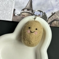 Handmade brown potato wool felt keychain with cute smile on white heart ceramic plate - Potato