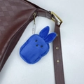 Detail der blauen Plüsch-Hasen-Geldbörse an einer braunen Ledertasche mit Metallkette - Dunkelblau