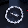 Macro detail of silver tennis bracelet with square and round zircon on black texture - White