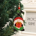 Nahaufnahme eines hölzernen Weihnachtswichtels mit Karomuster an einem Weihnachtsbaum - Geschenktüten Stil
