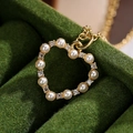 Gold-plated heart necklace with white pearls and zircons on green velvet background - Gold Pearl Rhinestone Heart