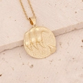 Macro view of 18K gold constellation pendant with claw-mark relief on a stone texture - 7#Leo